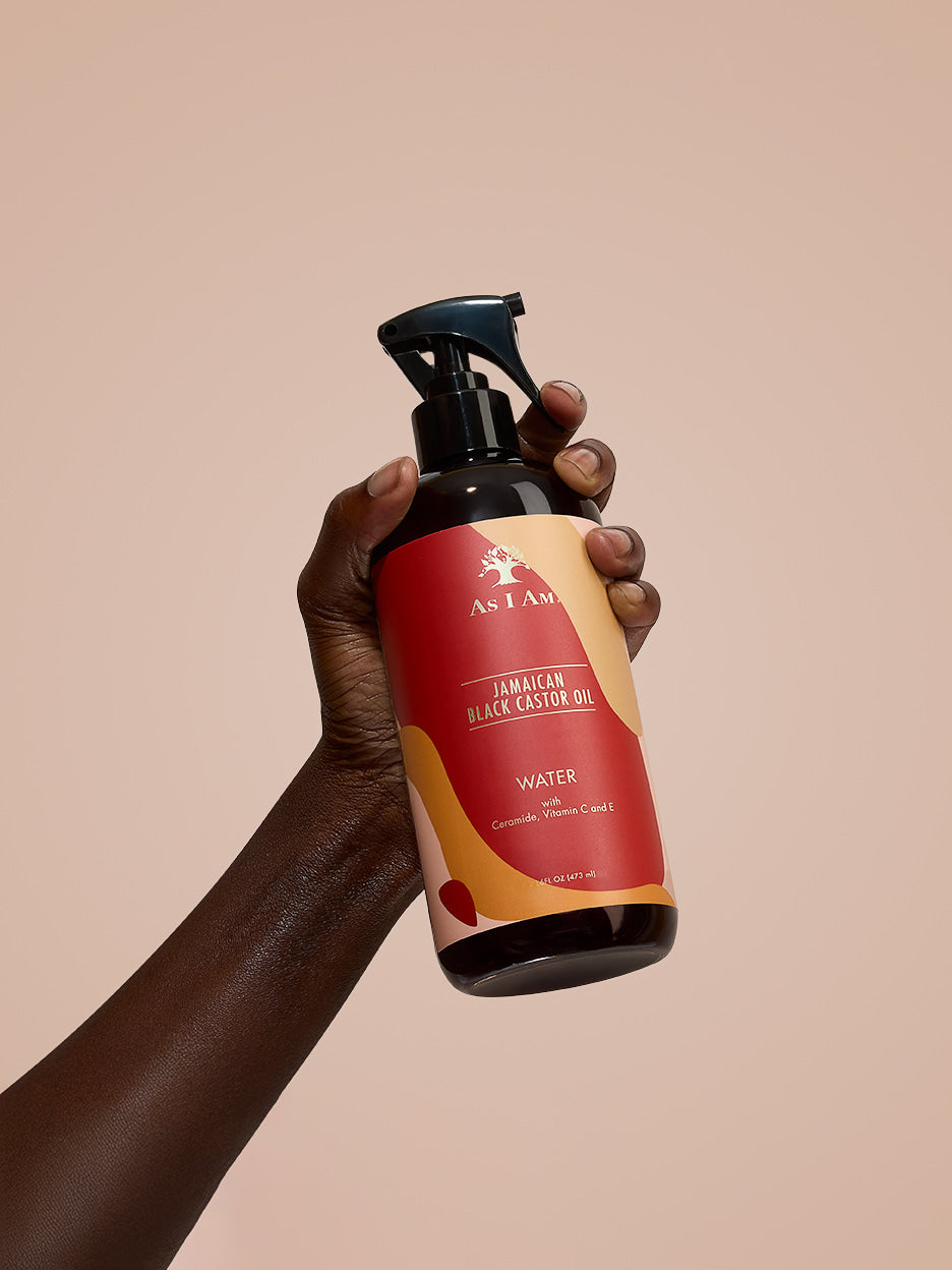 As I Am Jamaican Black Castor Oil Water — portrait shot of the hydrating spray bottle held in hand, highlighting its lightweight, JBCO-infused formula for refreshing and moisturizing natural curls.