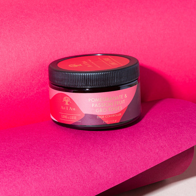 A container of Long & Luxe Groedges Edge Control hair product on a bright pink background.