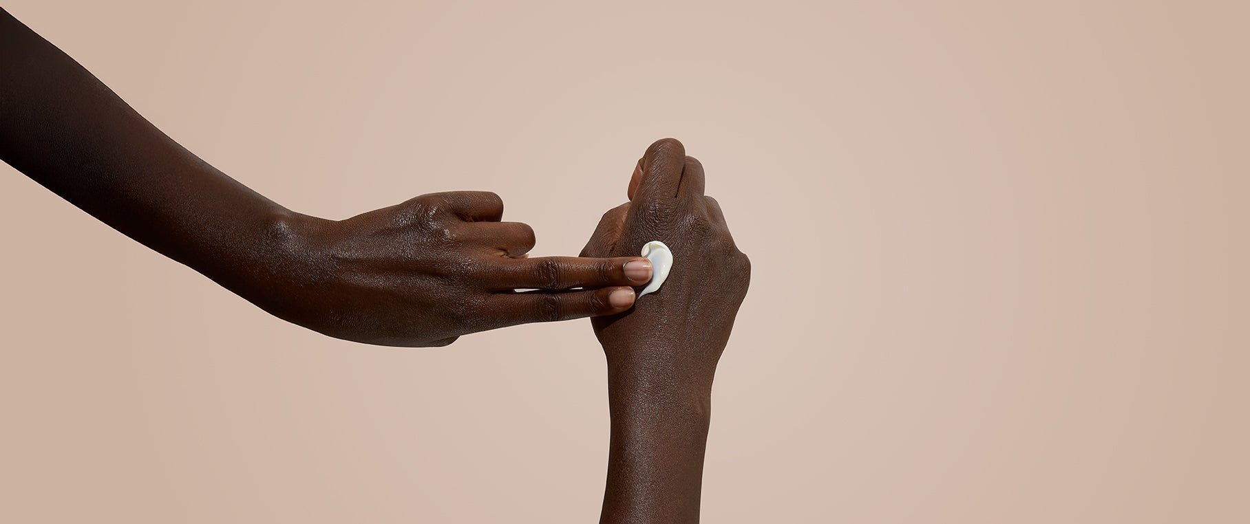 Two hands reaching towards each other with a neutral background