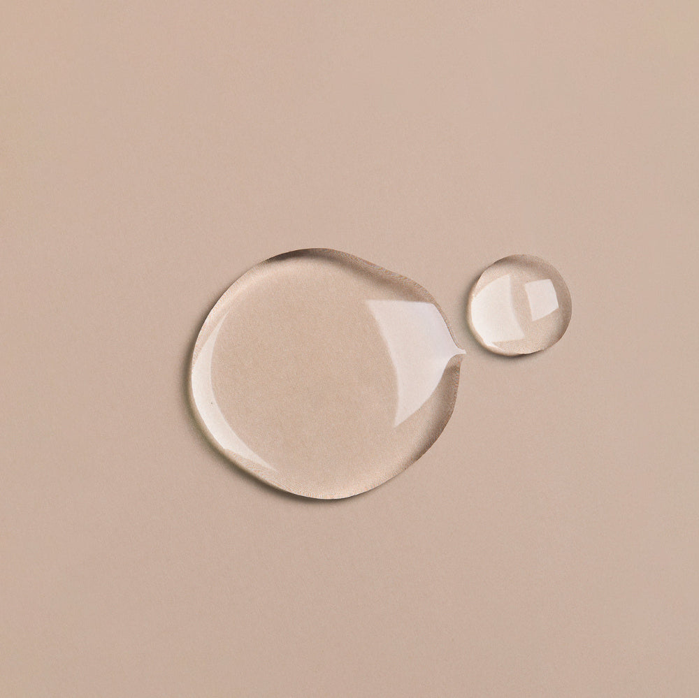 Two water droplets on a beige background