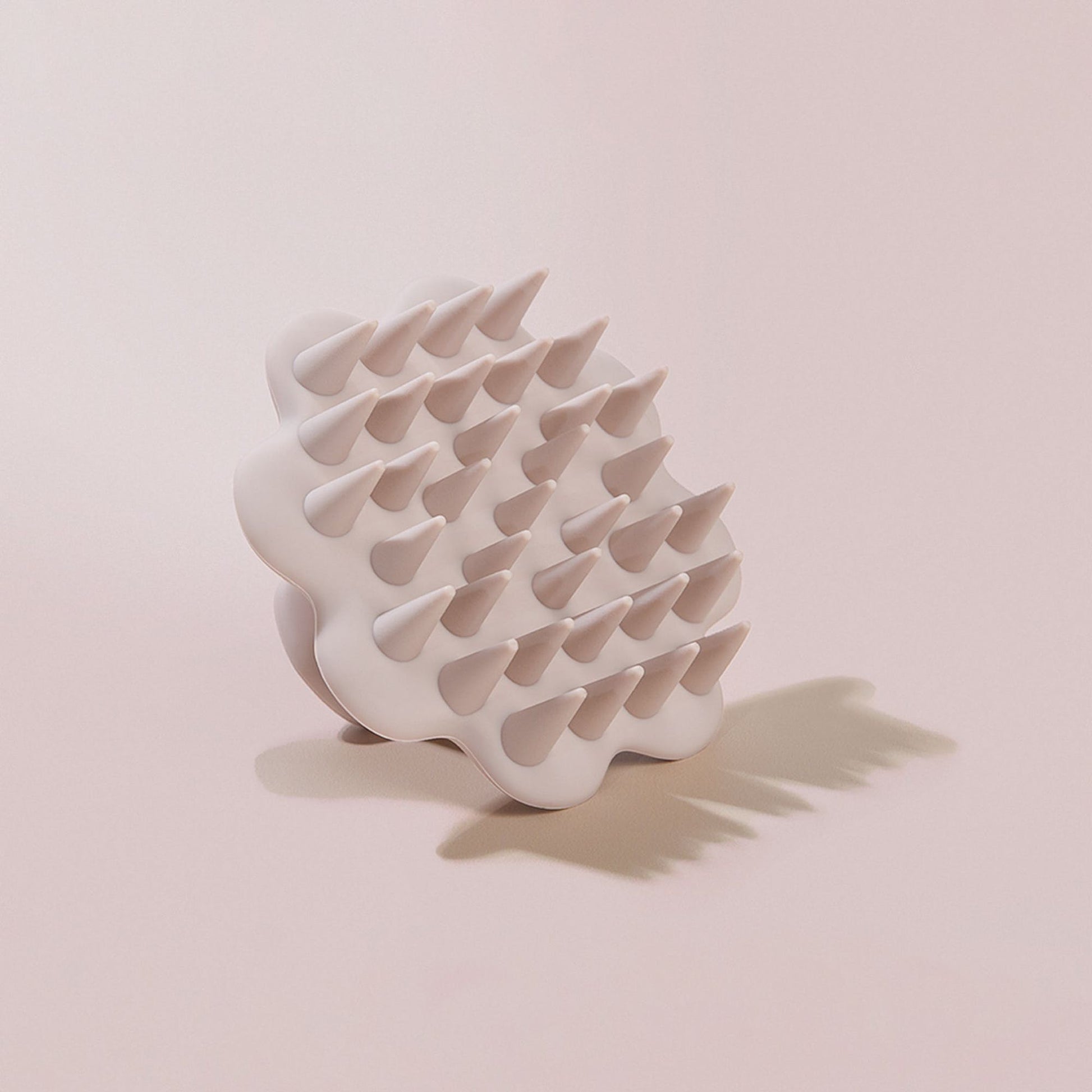 Beige scalp brush on beige background plain