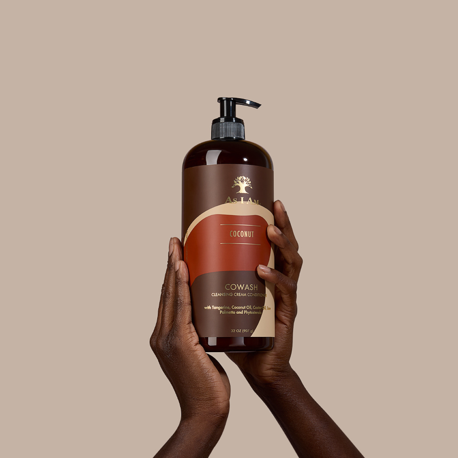 Brown bottle with pump held by hands against a beige background