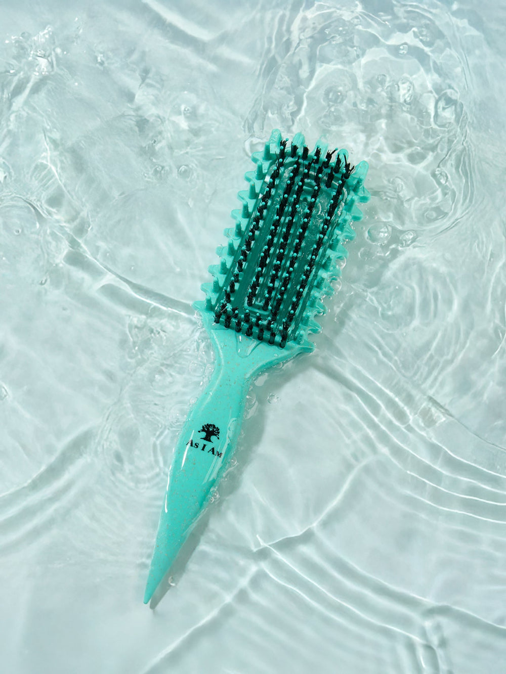 Turquoise hairbrush with black bristles on a textured white surface