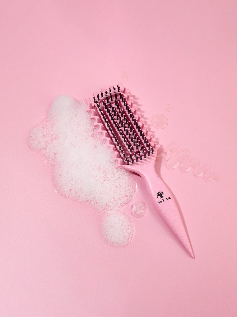 Pink hairbrush with bristles on a pink background