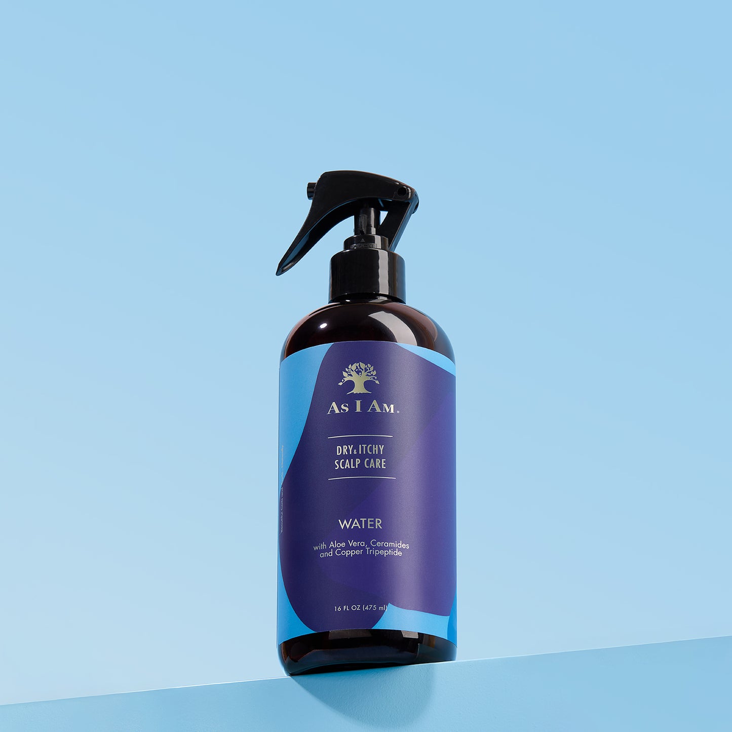 Bottle of As I Am dry itchy scalp care product on a blue background