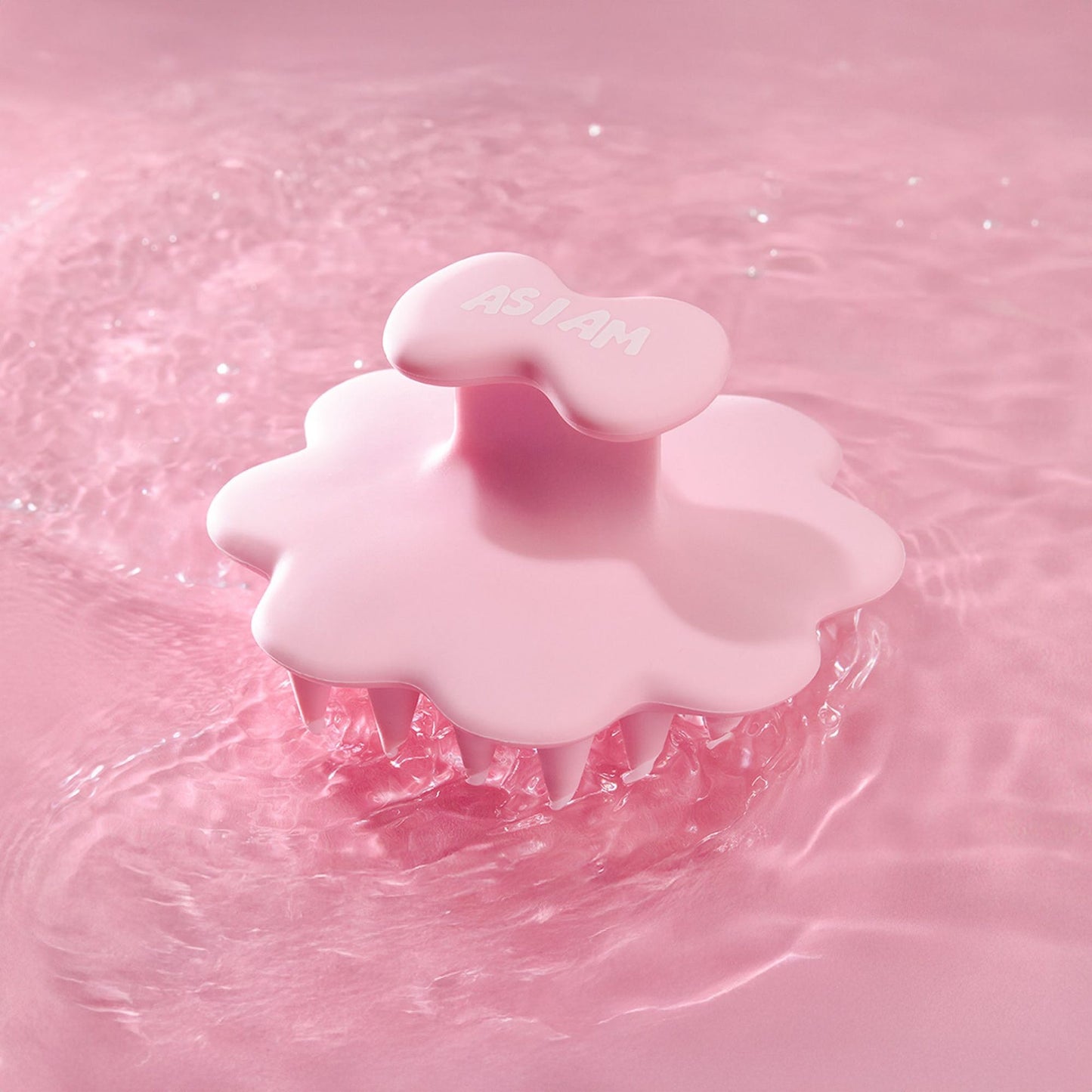 Pink scalp brush on a pink water background