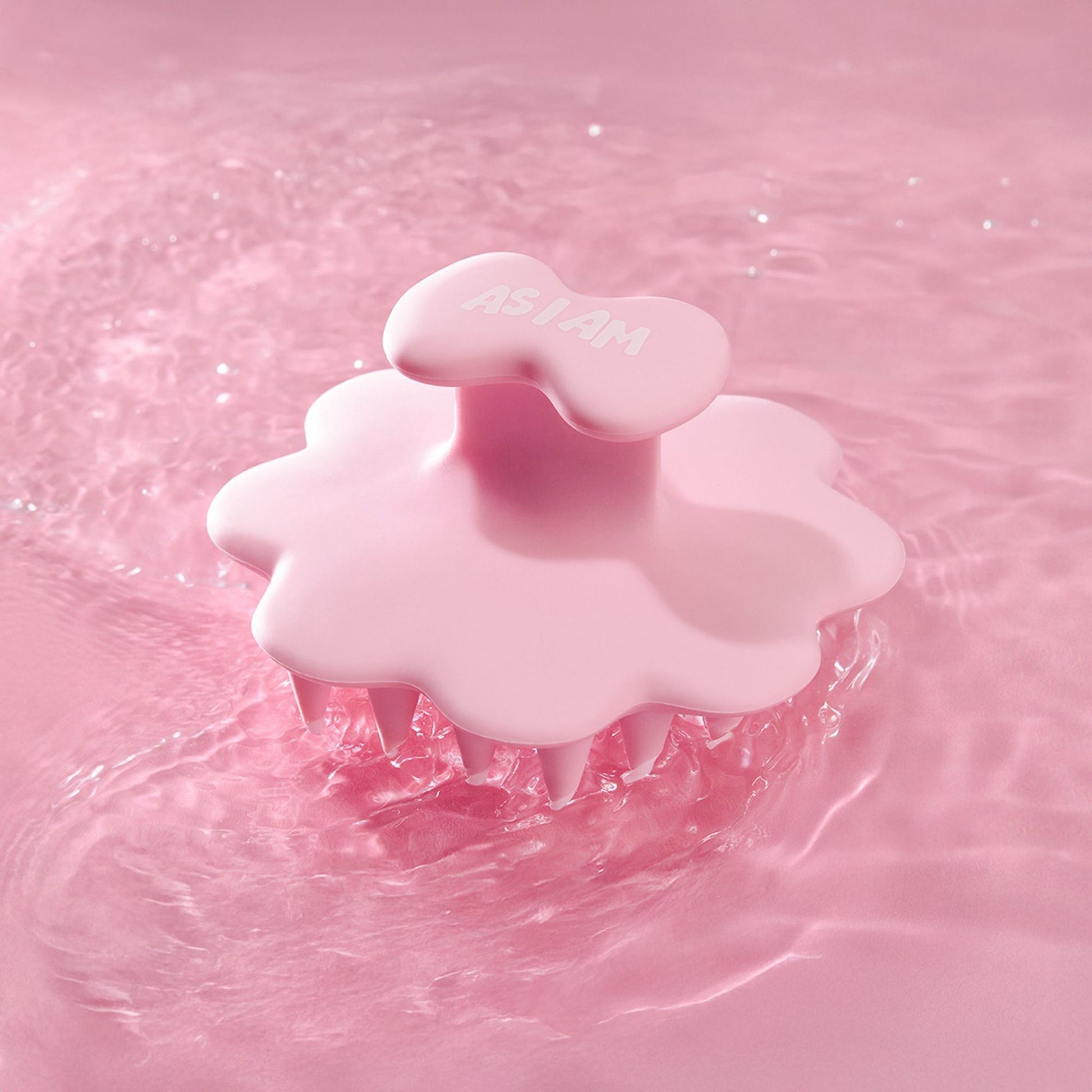 Pink scalp brush on a pink water background