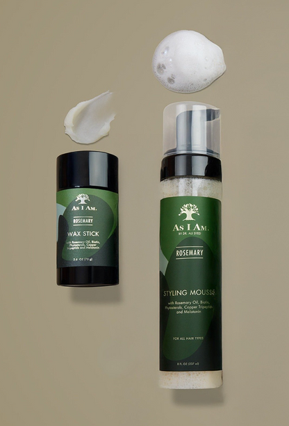 As I Am hair care products including a wax stick and styling mousse on a beige background