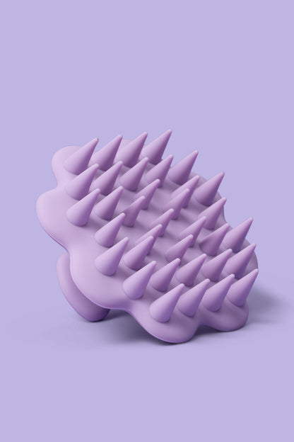Purple silicone scrubber with pointed ends on a light purple background