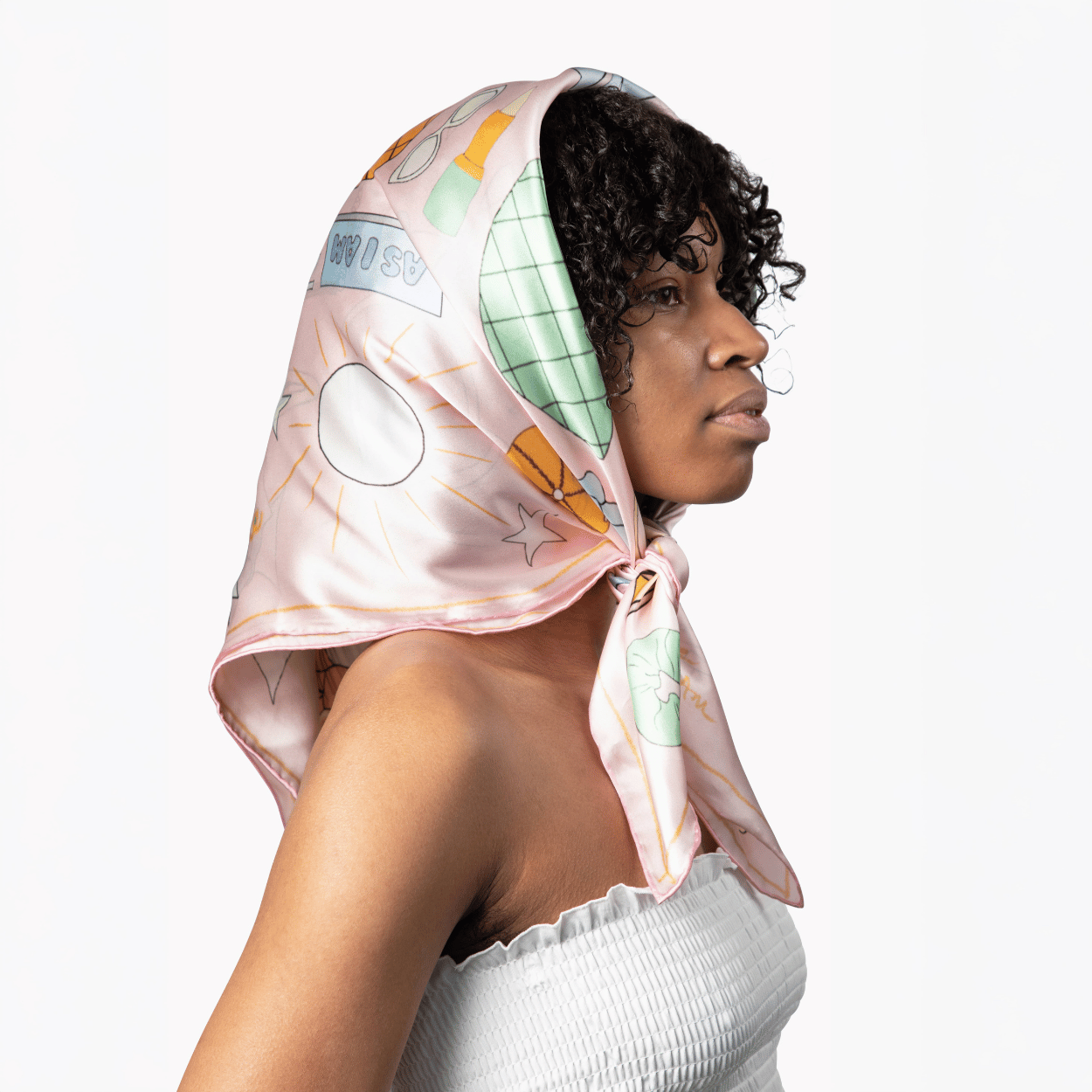 Woman wearing a colorful scarf with space-themed design on a white background