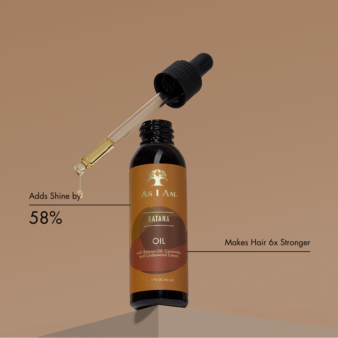 Bottle of As I Am Batana Oil with dropper on a brown background