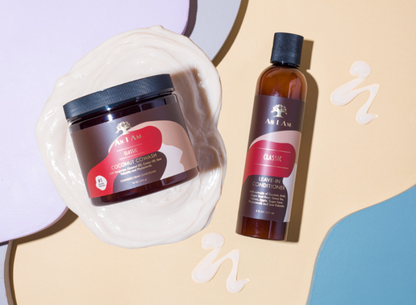 Two hair care products, a jar and a bottle, on a beige background with decorative elements.