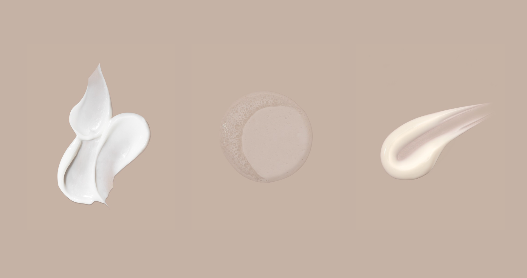 Three swatches of white cream on a beige background