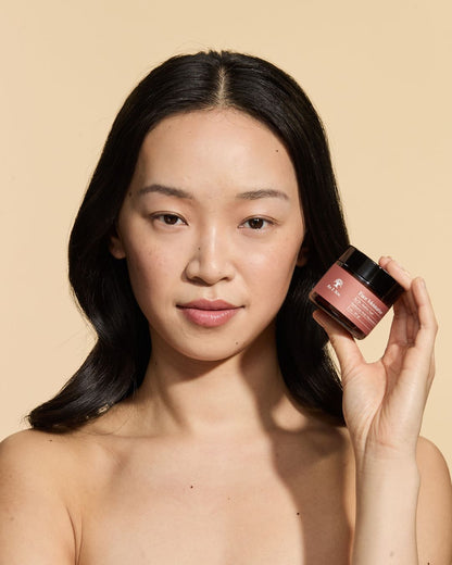 Woman holding the As I Am face moisturizer.