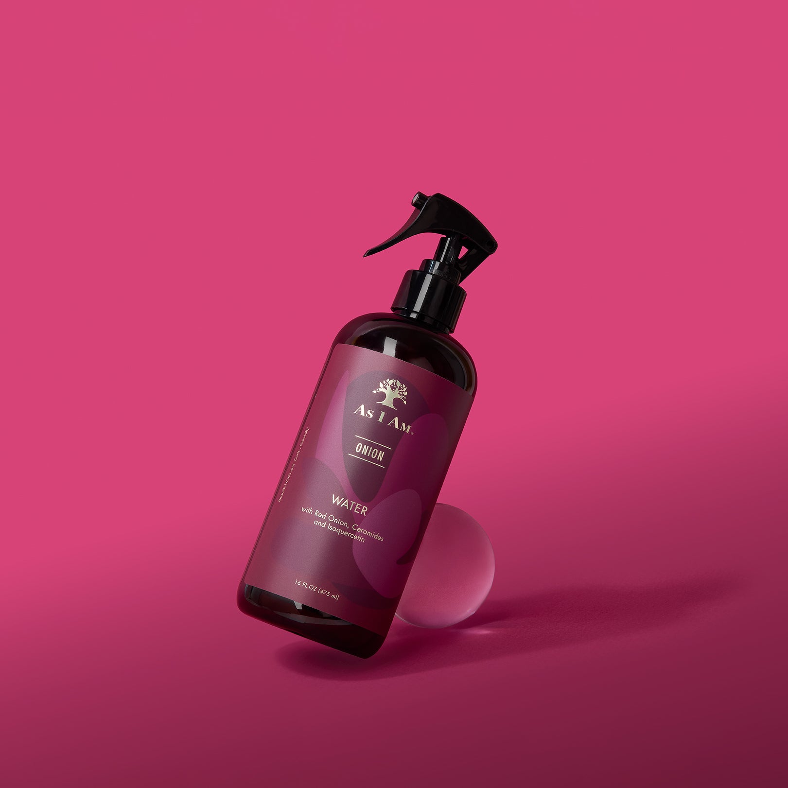 Bottle of As I Am hair product on a pink background