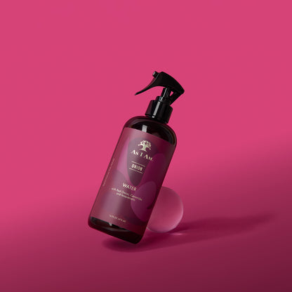 Bottle of As I Am hair product on a pink background