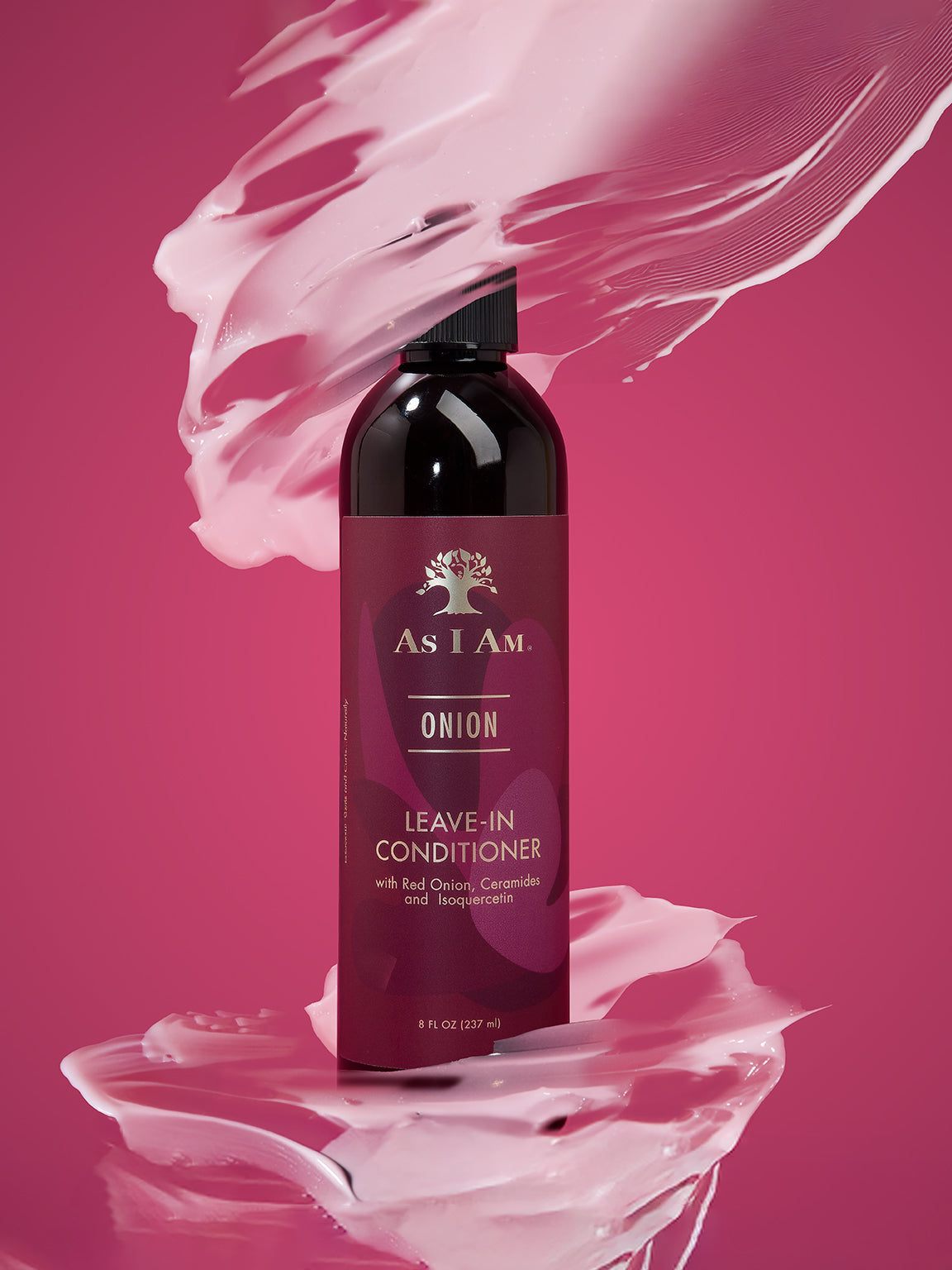 Bottle of As I Am Onion Leave-In Conditioner on a pink background