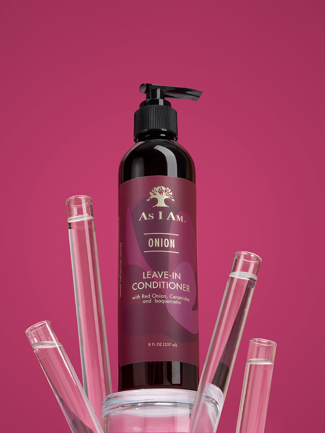 Bottle of As I Am Onion Leave-In Conditioner with pump on a pink background