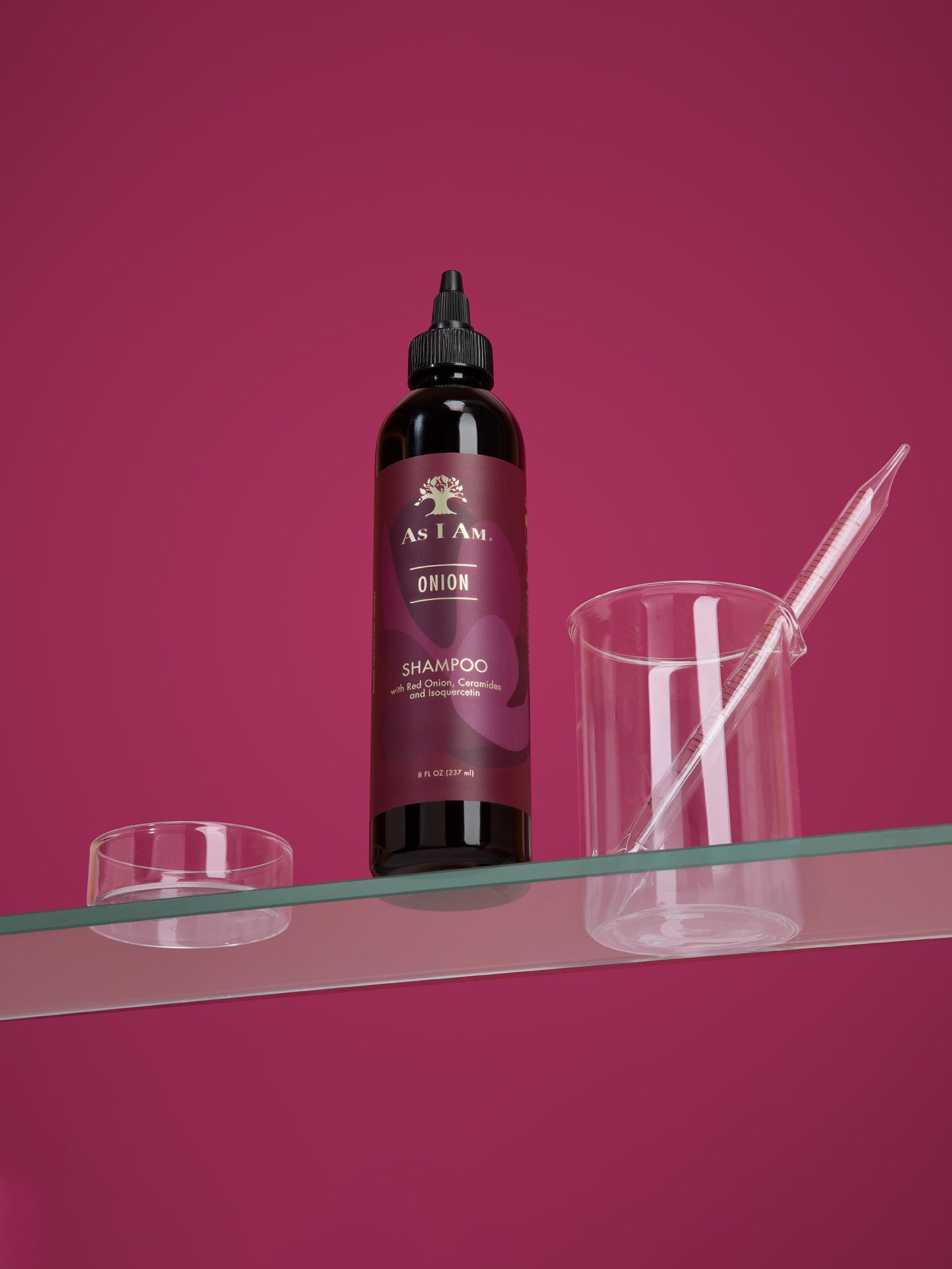 Bottle of As I Am Onion Shampoo on a clear surface with a pink background
