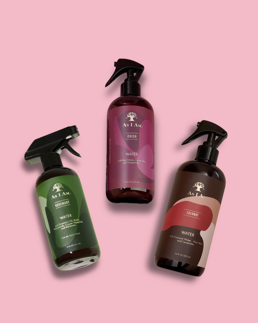 Three bottles of As I Am hair care products on a pink background